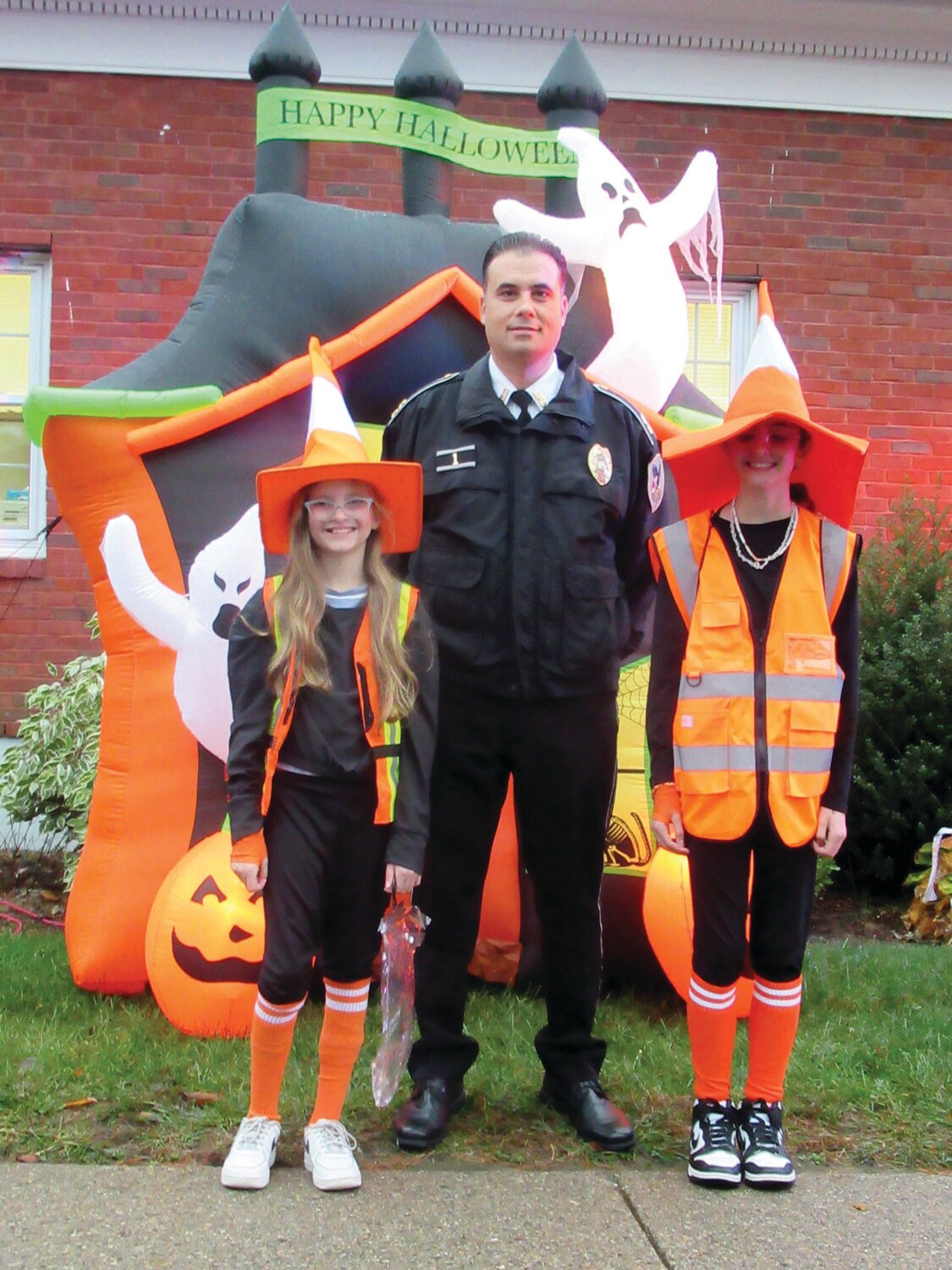 HAPPY HALLOWEEN: Johnston Police Chief Mark Vieira welcomed Victoria Anreozzi and Page Sousa, who wore special hats to Monday’s Trunk or Treat.